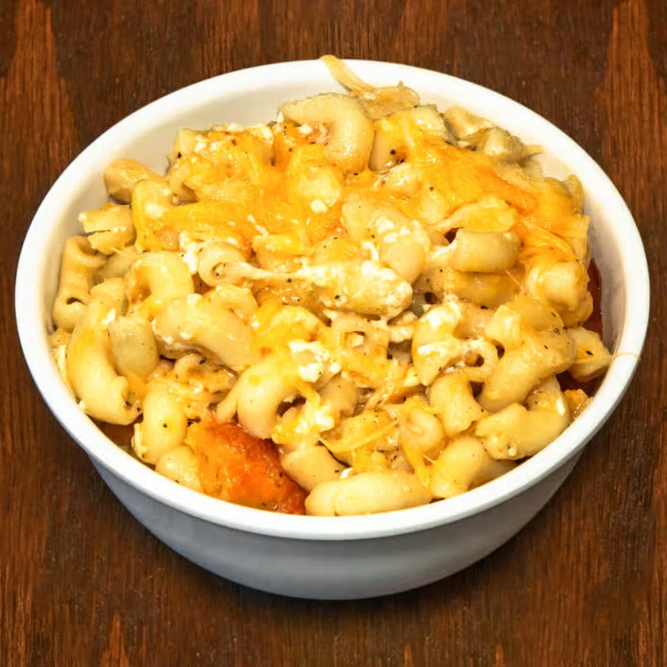 A white bowl filled with Dad's BBQ Next Generation mac and cheese, topped with melted cheddar.