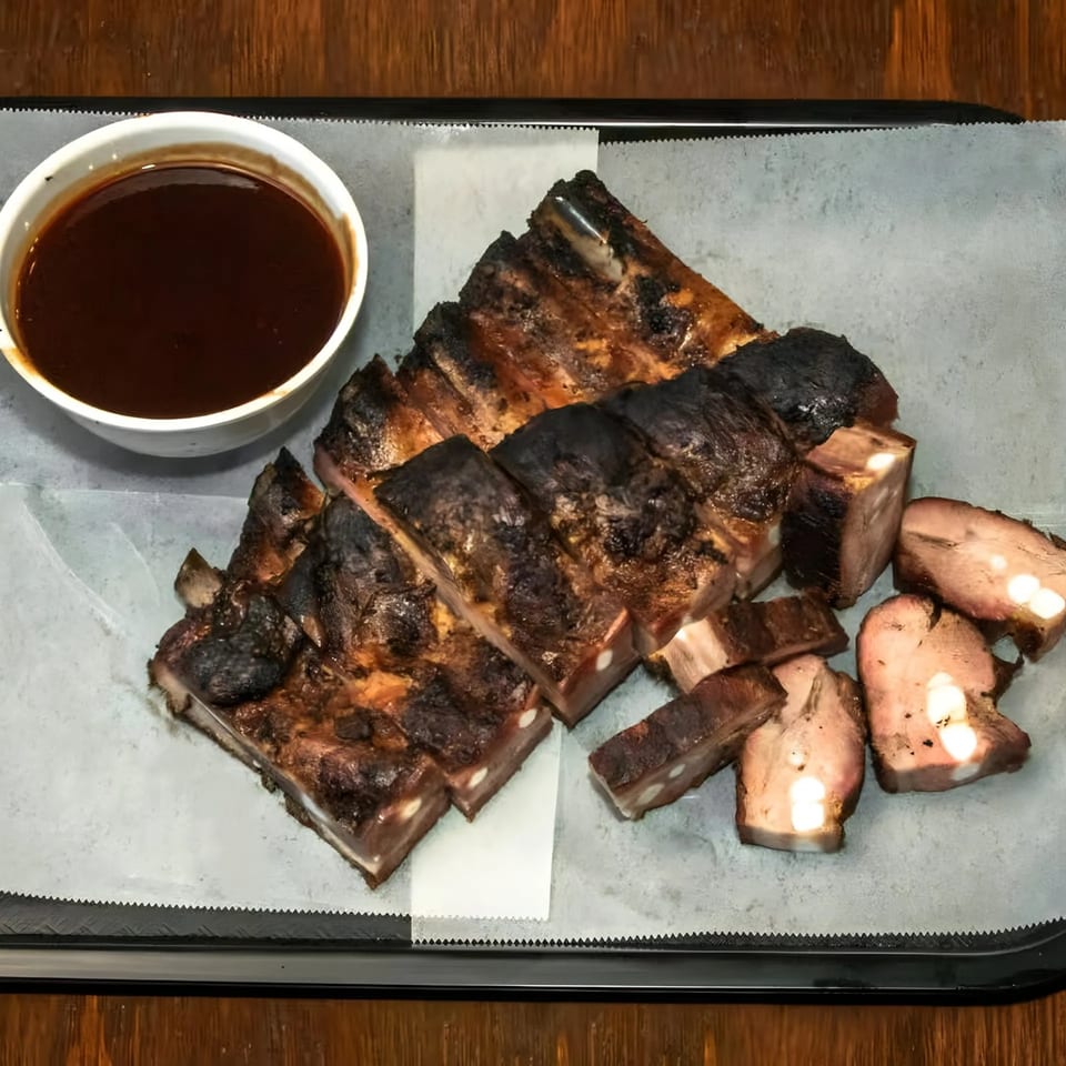 Dad's BBQ Next Generation ribs, cut into pieces, with a side of barbecue sauce.