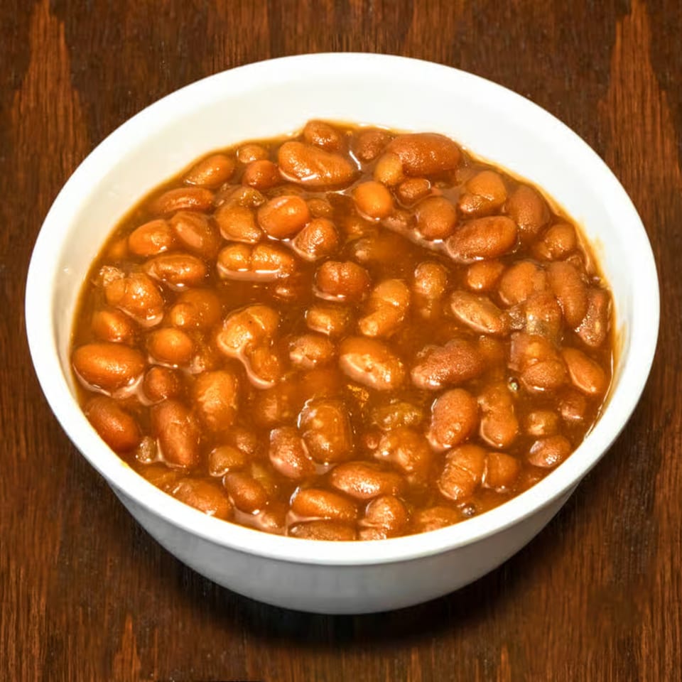 A white bowl filled with Dad's BBQ Next Generation baked beans in a rich, savory sauce.