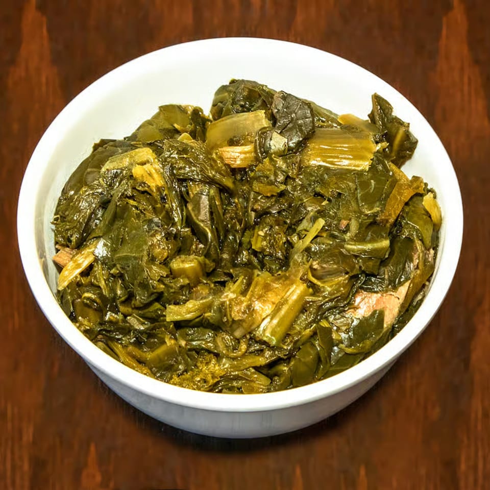 A white bowl filled with dark green collard greens, a classic BBQ side dish.