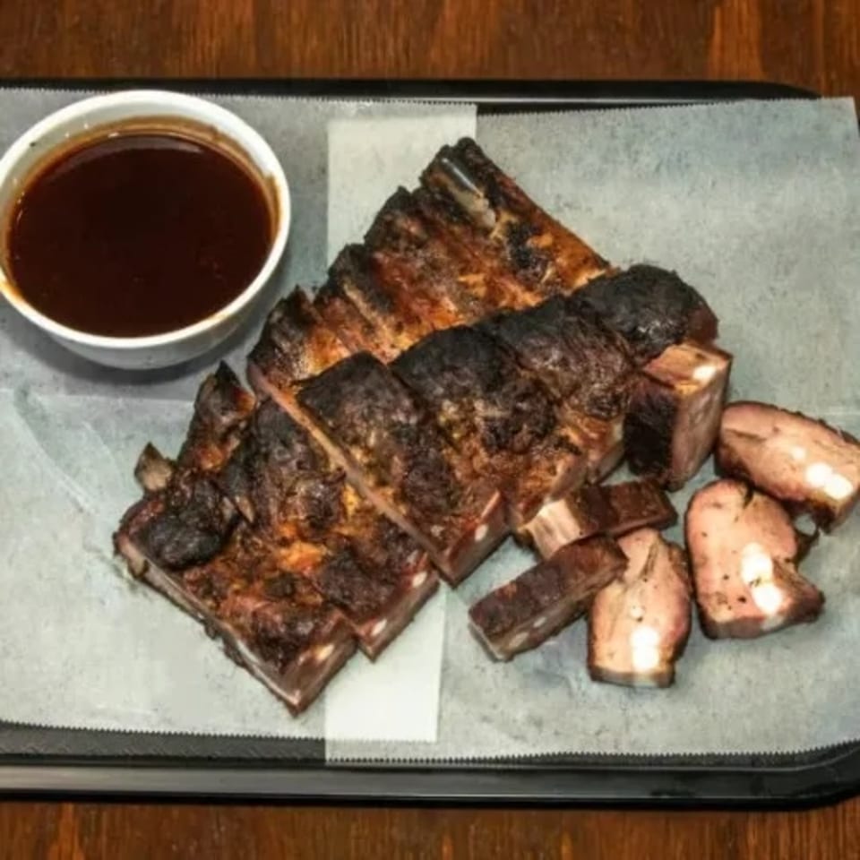Dad's BBQ Next Generation ribs, sliced and served with a side of barbecue sauce.